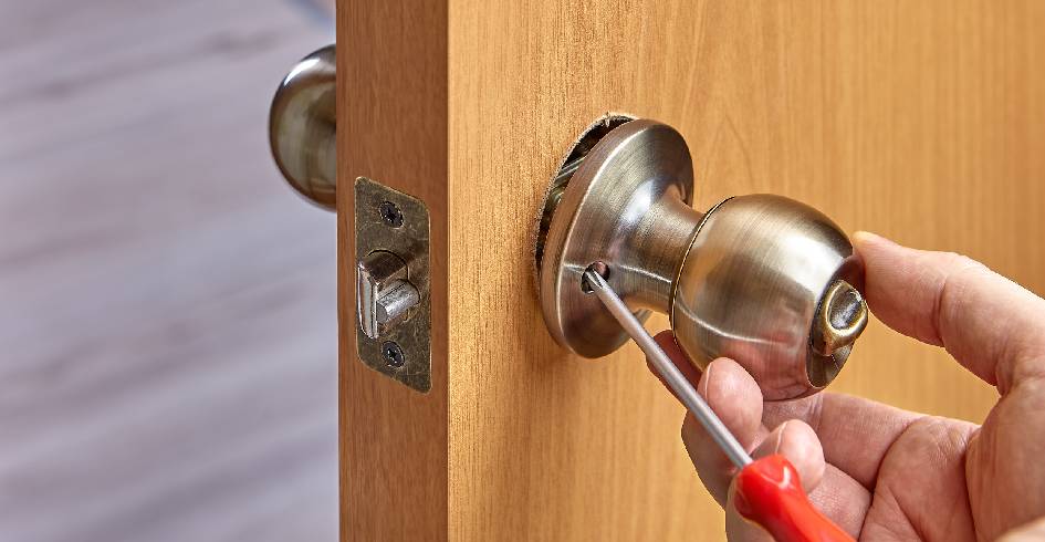 cerrajero cambiando cerradura de puerta efectuando servicio de cerrajería